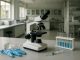 Pesquisador manipula frascos de vacina em laboratório