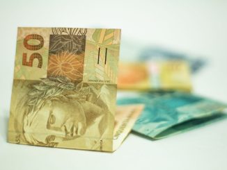 Moedas e cédulas de real sobre uma superfície