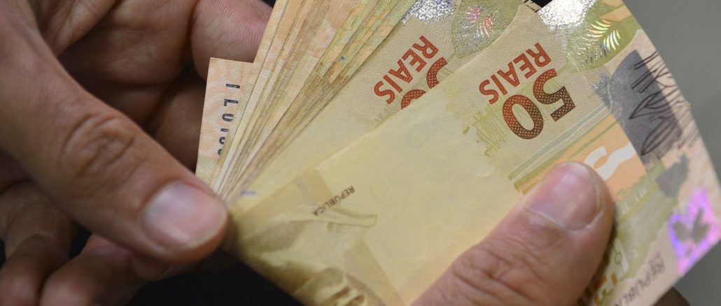 Notas e moedas de real sobre uma superfície. Foto: Agência Brasil