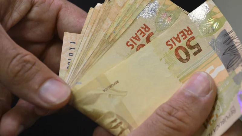 Notas e moedas de real sobre uma superfície. Foto: Agência Brasil