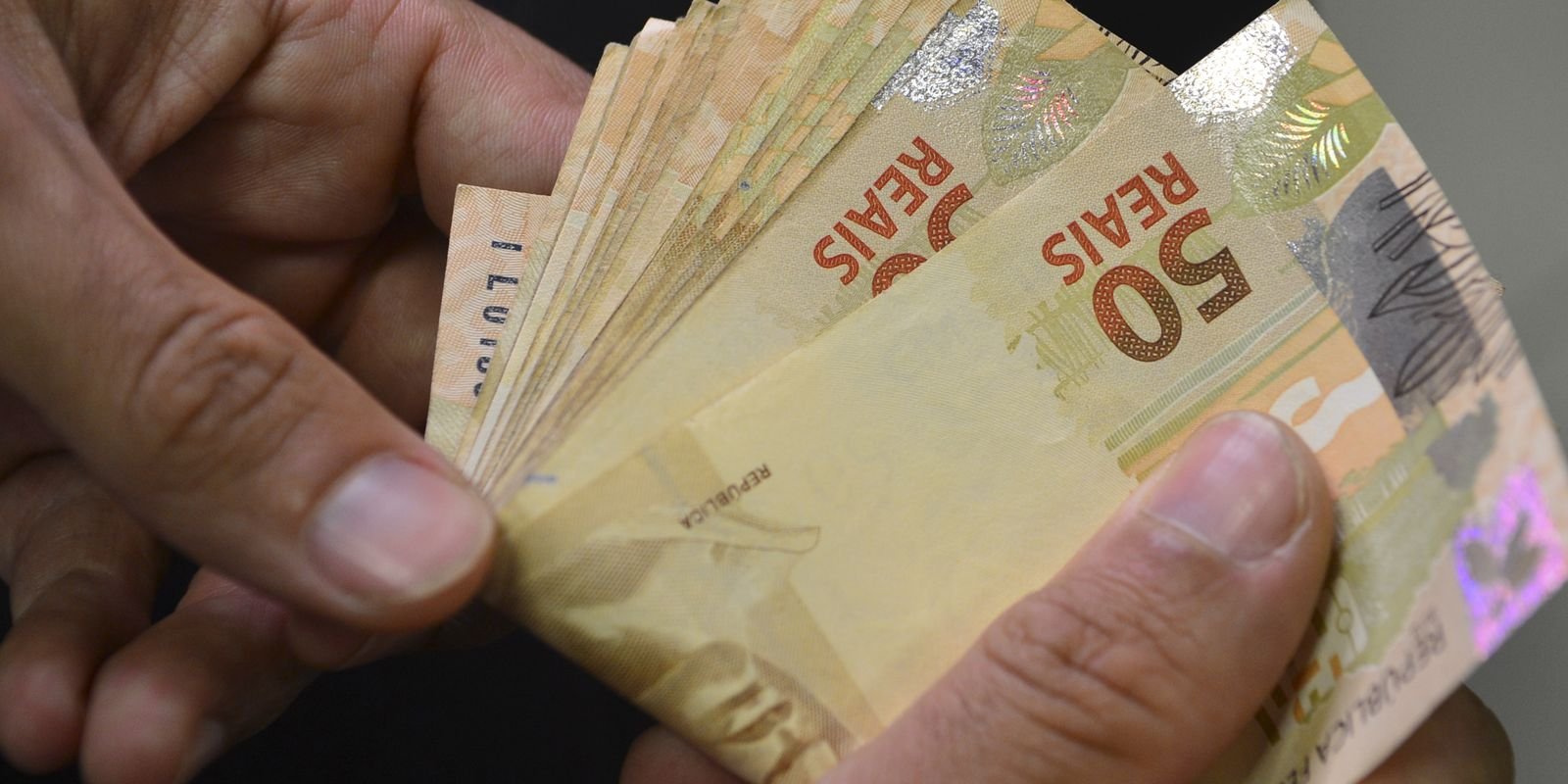 Notas e moedas de real sobre uma superfície. Foto: Agência Brasil