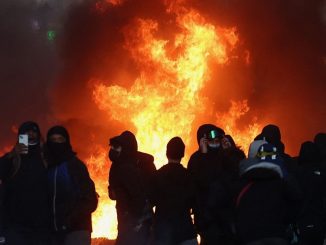 Policiais e manifestantes em rua de Paris durante protestos contra os preços altos
