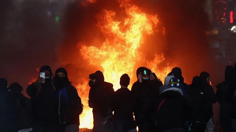 Policiais e manifestantes em rua de Paris durante protestos contra os preços altos