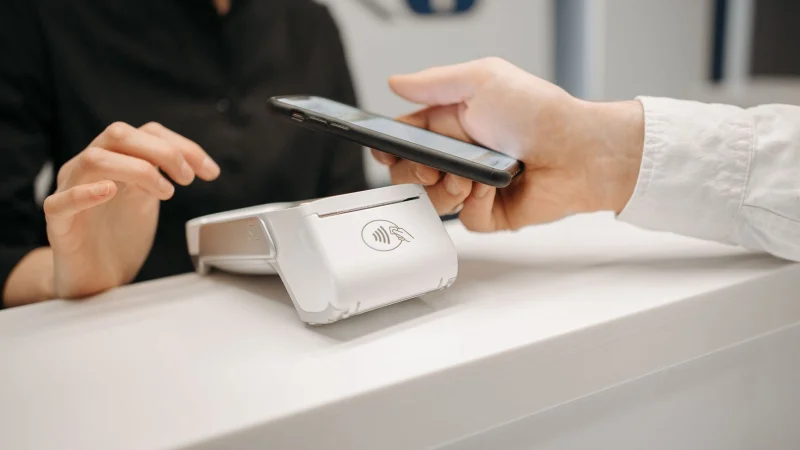Cliente aproxima o celular de uma maquininha para pagar com Pix por aproximação